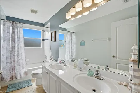 a bathroom with a double vanity sink mirror and toilet