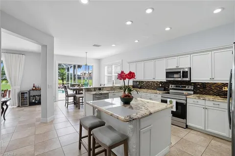 a kitchen with a dining table cabinets appliances and living room