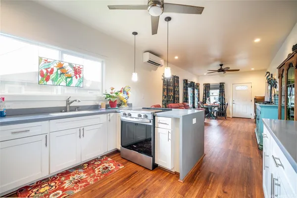 a kitchen with stainless steel appliances granite countertop a lot of counter space and wooden floors