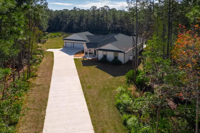 an aerial view of a house with swimming pool and garden