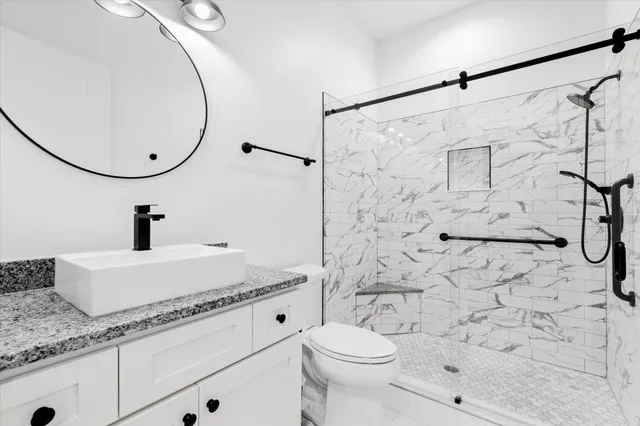 a kitchen with stainless steel appliances granite countertop a stove top oven a sink dishwasher a dining table and chairs with wooden floor