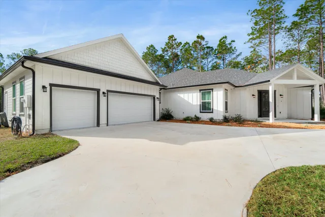 an aerial view of residential house with outdoor space and trees all around