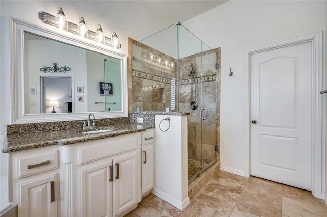 a spacious bathroom with a granite countertop tub sink a mirror a shower and vanity