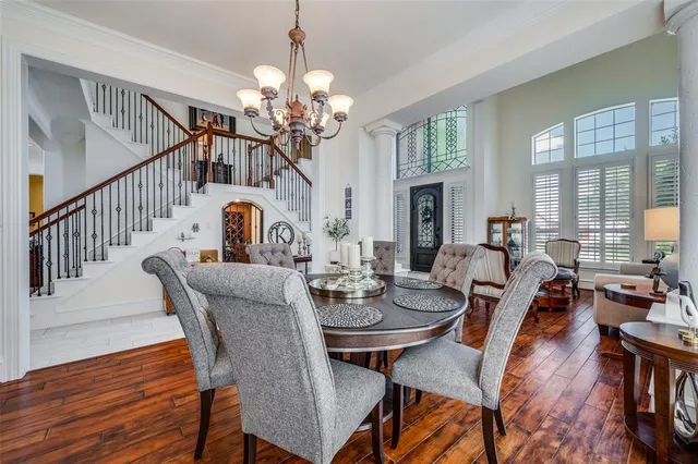 a view of a dining room with furniture a chandelier and wooden floor