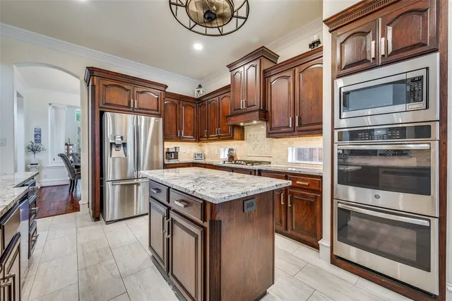 a kitchen with stainless steel appliances granite countertop a stove microwave and a refrigerator