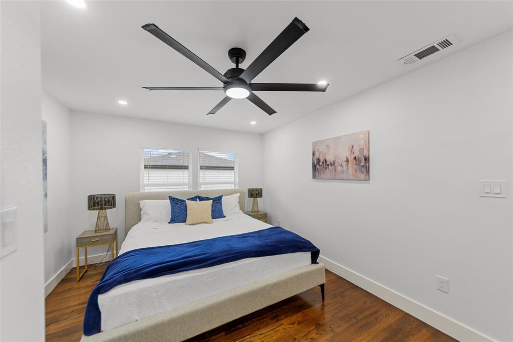 2945 Healey Drive Dallas, TX 75228 - Photo 12 of 38 a bedroom with a bed and a chandelier