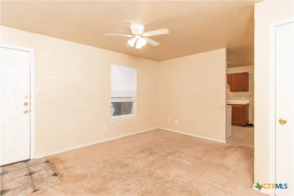 a view of a livingroom with a ceiling fan and window