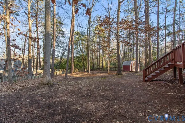 a view of a house with a yard and wooden fence