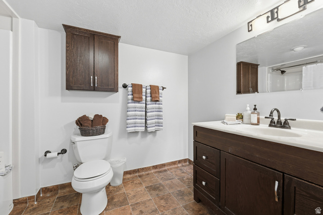2342 Charros Road Sandy, UT 84092 - Photo 55 of 94 Bathroom featuring a dark wood-finish vanity with an integrated sink, a wall-mounted mirror, and a shower with a white curtain