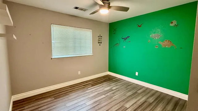 a view of a room with window ceiling fan and hallway