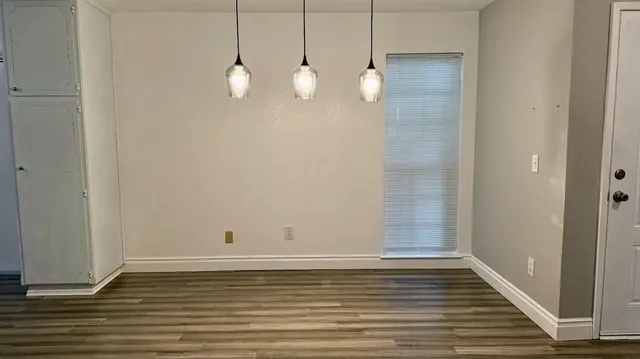 a view of a room with wooden floor and white walls