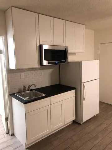 a kitchen with white cabinets and white appliances