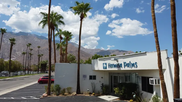 a front view of multi story residential apartment building with yard and sign board