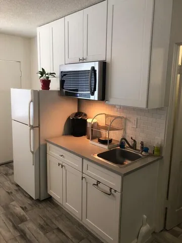a kitchen with a sink and white cabinets