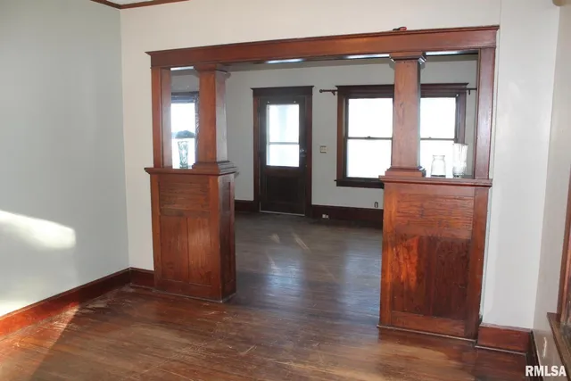 a view of a hallway with wooden floor and windows