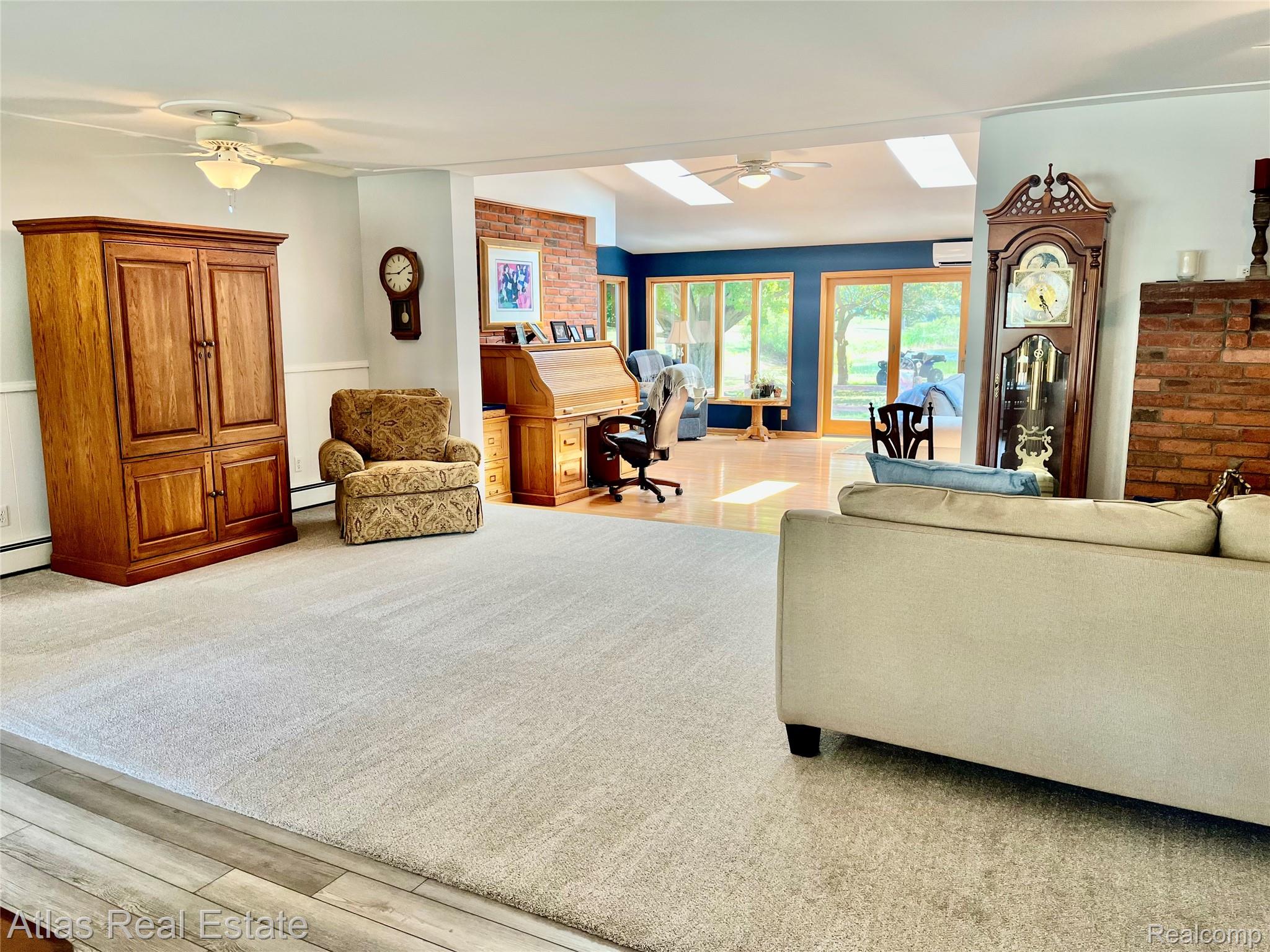 12026 Coolidge Road Goodrich, MI 48438 - Photo 31 of 56 Expansive room featuring carpet flooring, a vaulted ceiling with skylights, and ceiling fans