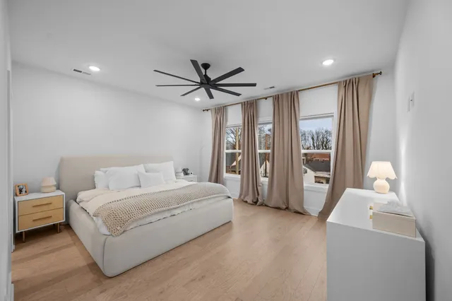 a living room with a bed furniture and a large window