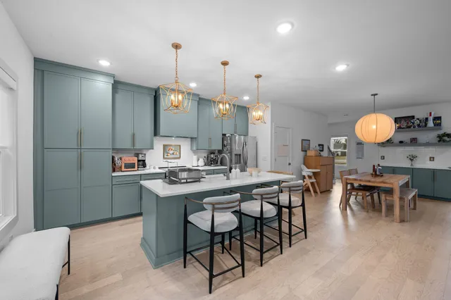 a kitchen with cabinets and chairs