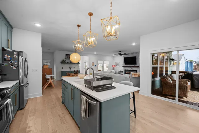 a kitchen with stove a refrigerator and chairs