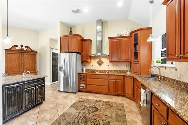 a kitchen with stainless steel appliances granite countertop a sink stove and refrigerator