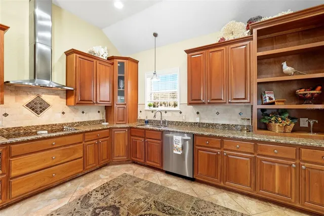 a kitchen with stainless steel appliances granite countertop a sink refrigerator and cabinets