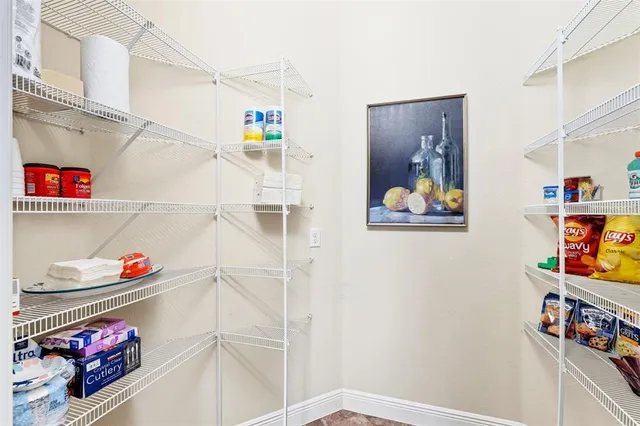 a bedroom with a large bed a flat tv screen and a dresser