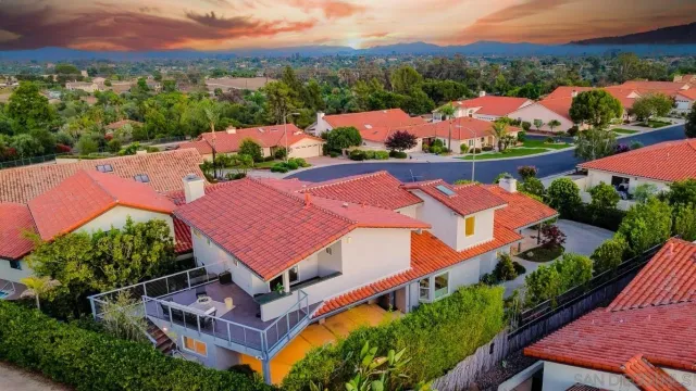 an aerial view of residential houses with outdoor space and a street view