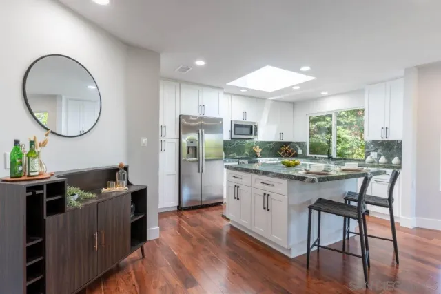 a kitchen with stainless steel appliances granite countertop a sink and a stove