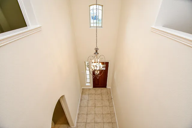a hallway with windows and chandelier