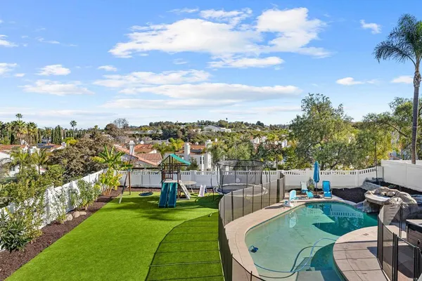 a view of a swimming pool and lounge chairs in the patio