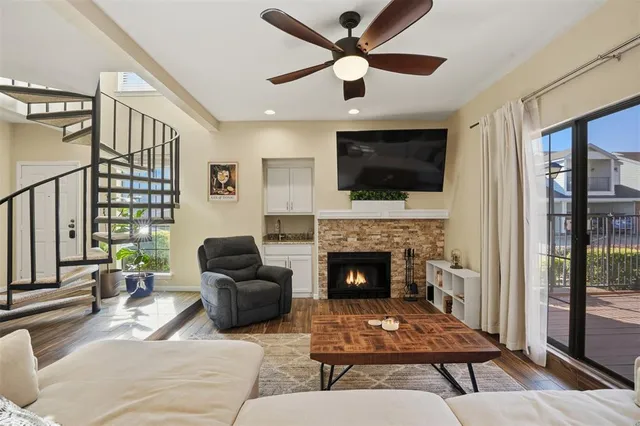a living room with furniture a flat screen tv and a fireplace