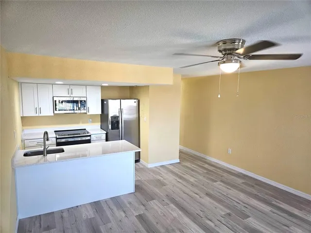 a kitchen with granite countertop white cabinets and stainless steel appliances