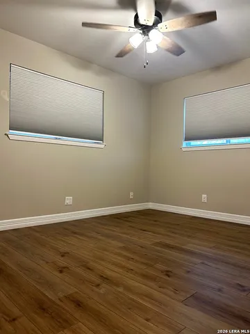 a view of a livingroom with an empty space wooden floor and flat screen tv