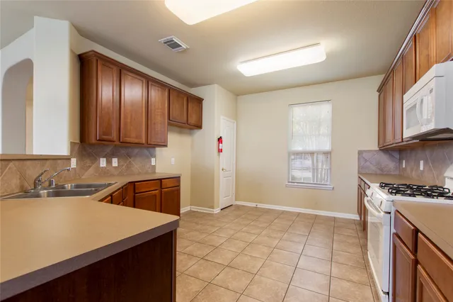 a kitchen with a sink a stove and cabinets