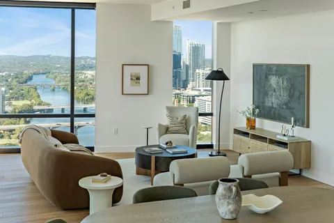 a living room with furniture and a floor to ceiling window