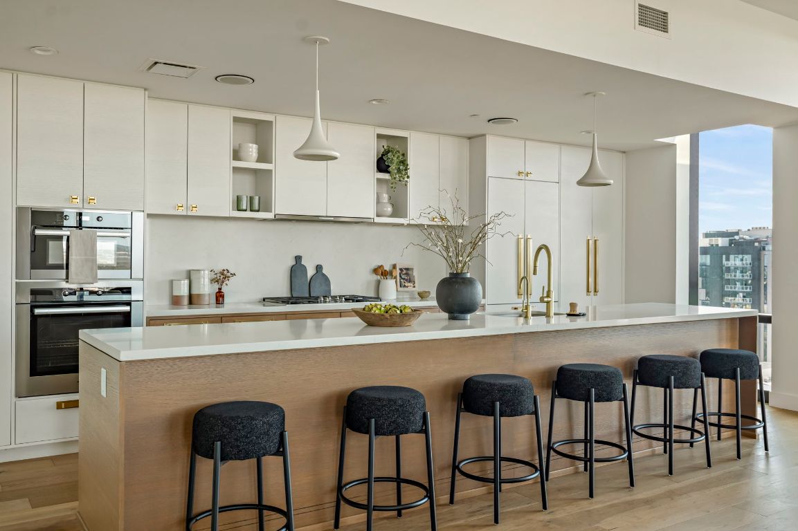 70 Rainey Street, Unit 2701 Austin, TX 78701 - Photo 12 of 40 a kitchen with stainless steel appliances granite countertop white cabinets and chairs