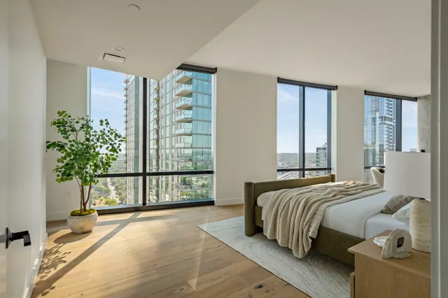 a bedroom with a large bed and a potted plant