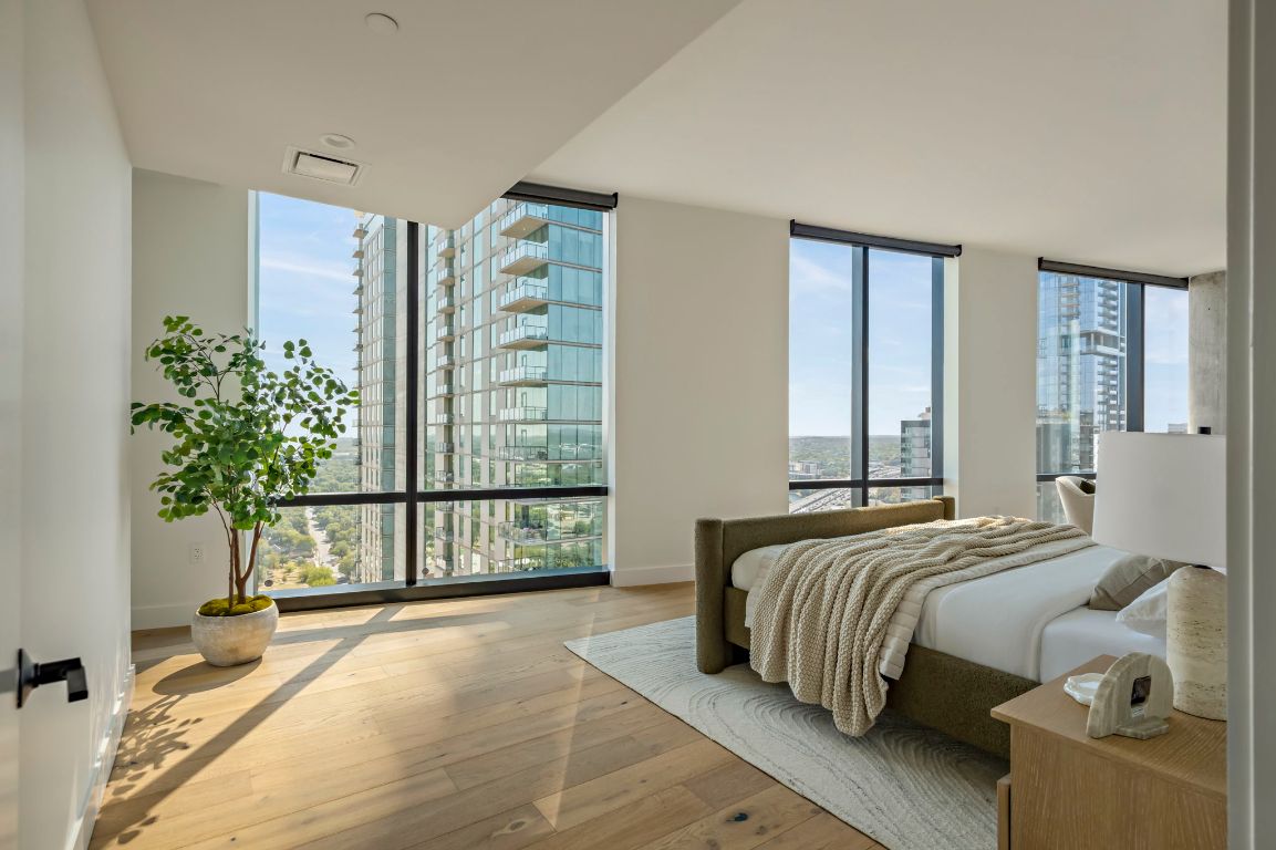 70 Rainey Street, Unit 2701 Austin, TX 78701 - Photo 16 of 40 a bedroom with a large bed and a potted plant