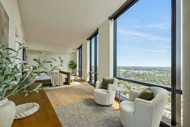 a living room with furniture and a floor to ceiling window