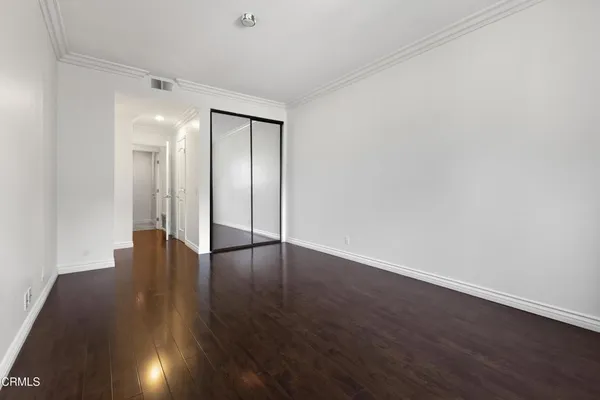 a view of an empty room with wooden floor
