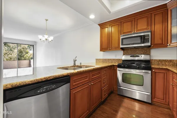 a kitchen with granite countertop stainless steel appliances a stove sink and microwave