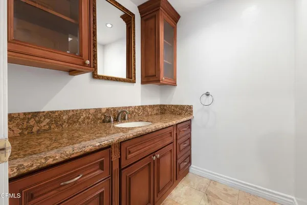 a bathroom with a granite countertop sink and a mirror
