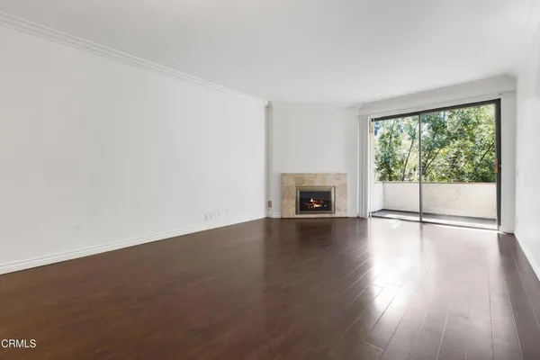 a view of empty room with wooden floor and fireplace