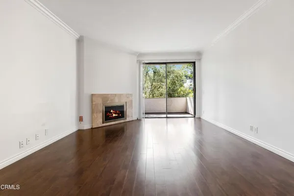 an empty room with wooden floor and fireplace