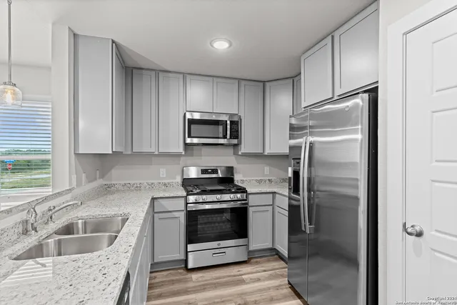 a kitchen with a refrigerator stove and sink
