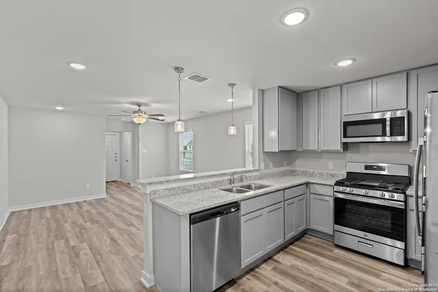 a kitchen with a stove a sink and a refrigerator