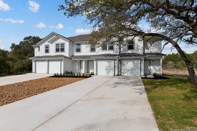 a front view of a house with a garden and yard