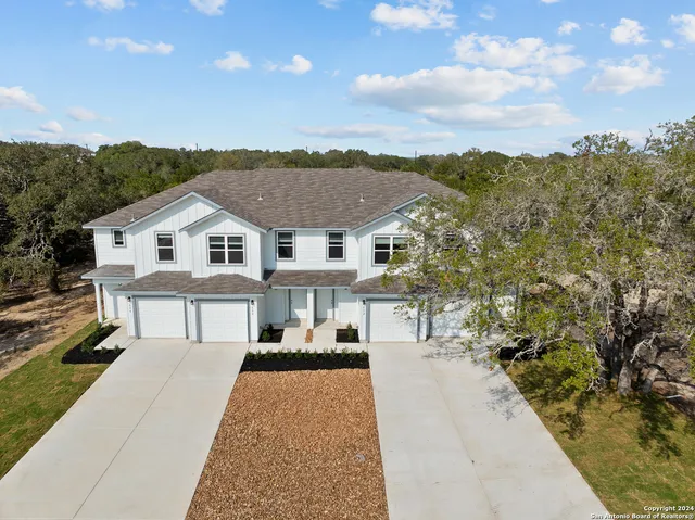 a view of house with yard and trees in the background