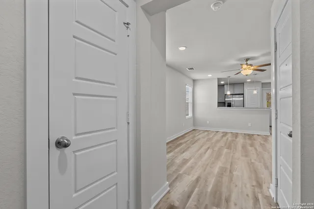 a view of a hallway with wooden floor and closet