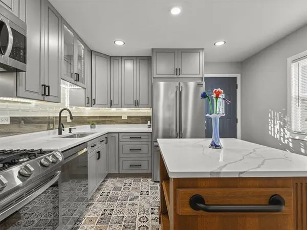 a view of kitchen island with stainless steel appliances stove refrigerator sink and stove